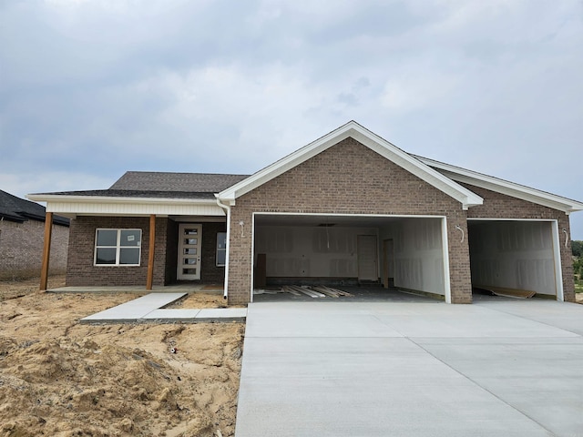 180 Kelton St, Hensley, AR 72065 - view of front facade featuring an attached garage, brick siding, and driveway