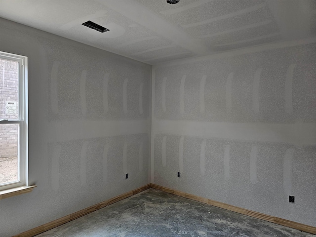 180 Kelton St, Hensley, AR 72065 - empty room featuring concrete flooring, healthy amount of natural light, and baseboards