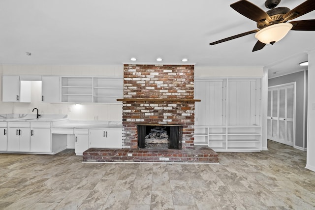 7011 W Markham St, Little Rock, AR 72205 - unfurnished living room featuring ceiling fan, a sink, recessed lighting, and a brick fireplace