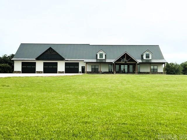 1656 Airport Dr, Mountain View, AR 72560 - modern farmhouse style home with a front lawn, concrete driveway, metal roof, and a garage