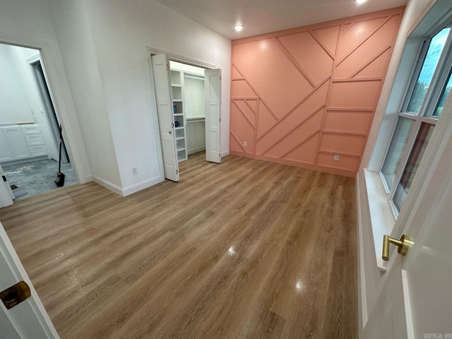 1656 Airport Dr, Mountain View, AR 72560 - unfurnished bedroom featuring baseboards, light wood-style floors, a decorative wall, recessed lighting, and connected bathroom