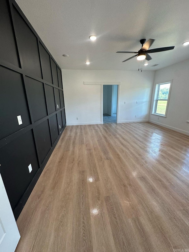 1656 Airport Dr, Mountain View, AR 72560 - empty room featuring a textured ceiling, light wood finished floors, ceiling fan, and baseboards