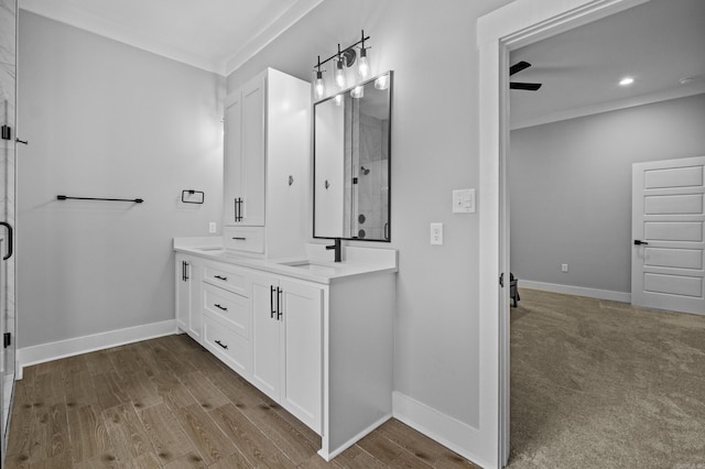 81 Fletcher Ridge Dr, Little Rock, AR 72223 - bathroom with double vanity, a shower with shower door, wood finished floors, baseboards, and ornamental molding