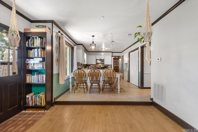 2006 Gunpowder Rd, Little Rock, AR 72227 - dining area with crown molding, baseboards, and light wood-style flooring