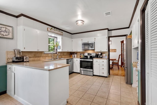 2006 Gunpowder Rd, Little Rock, AR 72227 - kitchen with appliances with stainless steel finishes, a sink, ornamental molding, a peninsula, and decorative backsplash