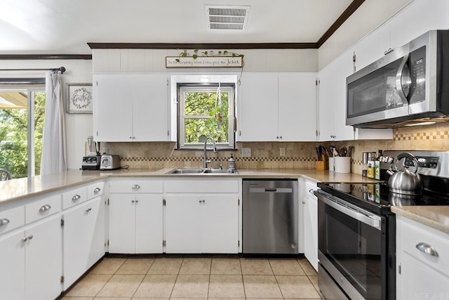 2006 Gunpowder Rd, Little Rock, AR 72227 - kitchen featuring appliances with stainless steel finishes, a sink, crown molding, plenty of natural light, and light countertops