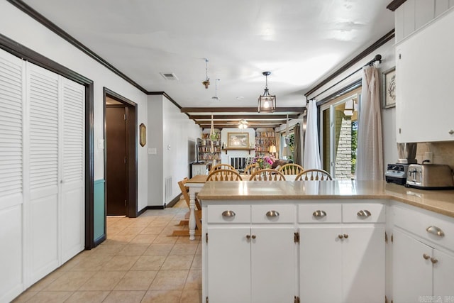 2006 Gunpowder Rd, Little Rock, AR 72227 - kitchen with a peninsula, white cabinets, light tile patterned floors, light countertops, and ornamental molding