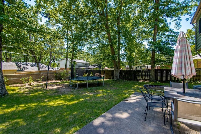 2006 Gunpowder Rd, Little Rock, AR 72227 - view of yard featuring a trampoline, outdoor dining space, and a patio area