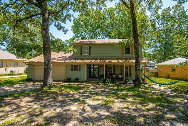 2006 Gunpowder Rd, Little Rock, AR 72227 - back of house featuring a garage, covered porch, concrete driveway, and brick siding