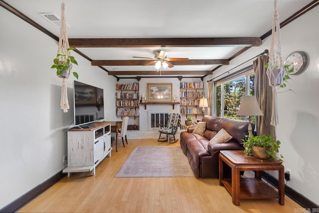 2006 Gunpowder Rd, Little Rock, AR 72227 - living area with ceiling fan, a glass covered fireplace, wood finished floors, baseboards, and beam ceiling