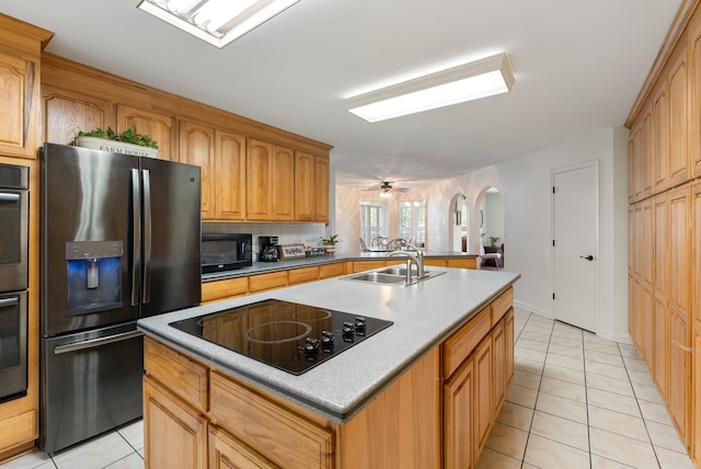 50 Merritt Trl, Greenbrier, AR 72058 - kitchen featuring black appliances, a sink, arched walkways, light tile patterned flooring, and an island with sink