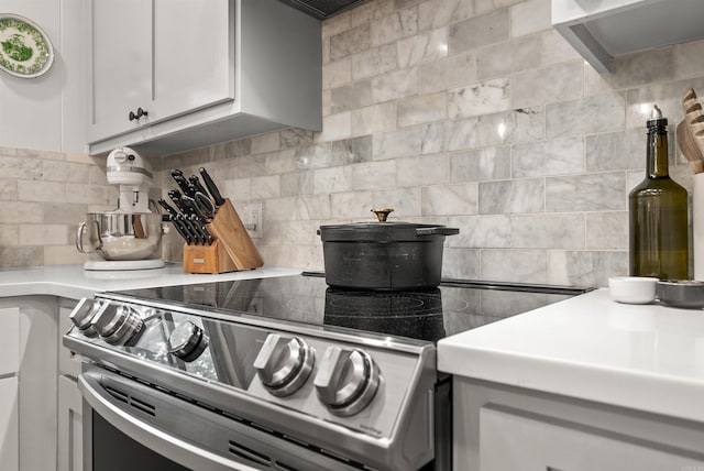 8010 Iowa Dr, Little Rock, AR 72227 - kitchen with stainless steel electric range oven, decorative backsplash, light countertops, and white cabinetry