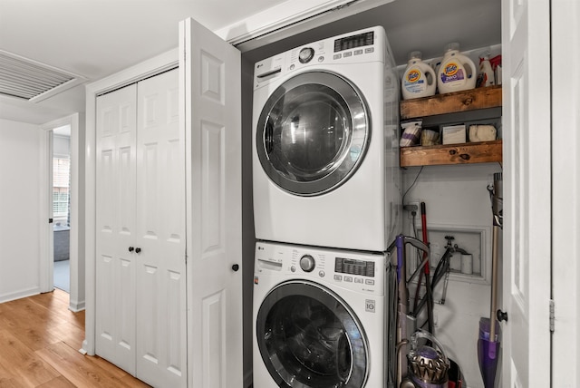 8010 Iowa Dr, Little Rock, AR 72227 - laundry room with estacked washer and dryer, light wood-type flooring, and baseboards