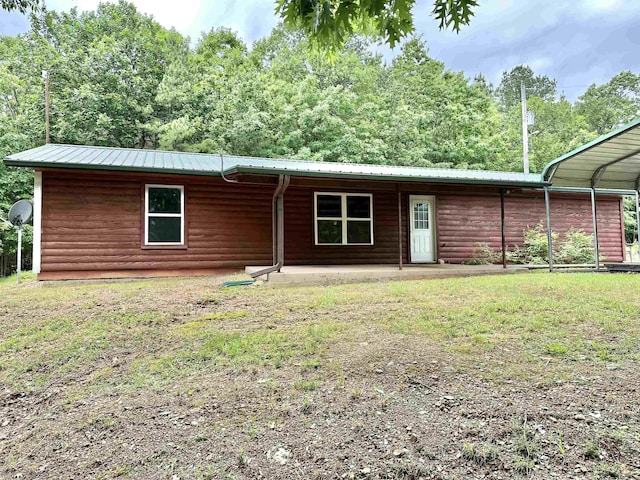 540 Polk Rd 78, Mena, AR 71953 - view of front of home featuring faux log siding, metal roof, a patio, a carport, and a front yard