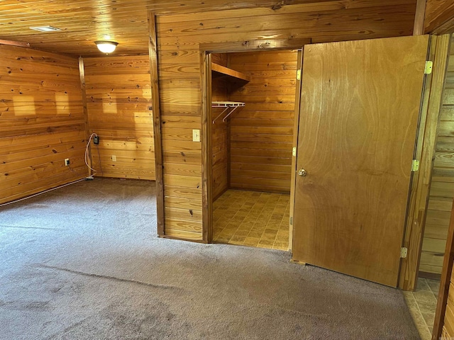 540 Polk Rd 78, Mena, AR 71953 - unfurnished bedroom featuring carpet floors, wood walls, a closet, and a walk in closet
