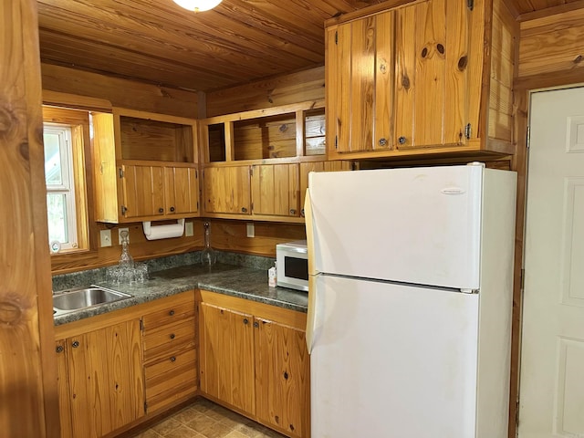 540 Polk Rd 78, Mena, AR 71953 - kitchen with freestanding refrigerator, wooden ceiling, dark countertops, a sink, and brown cabinets