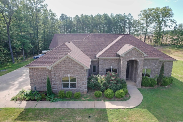 23 Whispering Dr, Alexander, AR 72002 - view of front of home featuring brick siding, a front yard, and roof with shingles