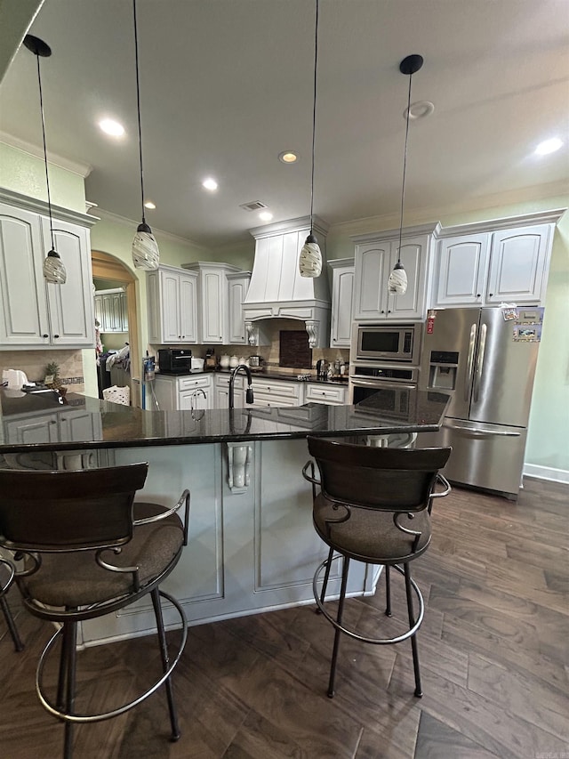 23 Whispering Dr, Alexander, AR 72002 - kitchen featuring stainless steel appliances, custom range hood, ornamental molding, a breakfast bar area, and a sink