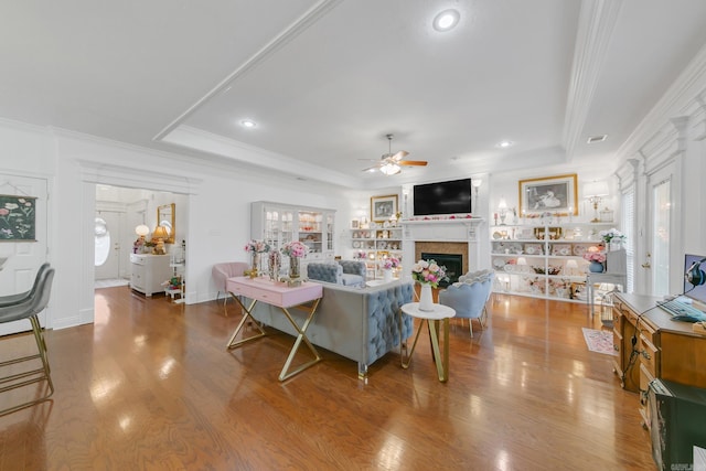 43 Earnhardt Cir, Cabot, AR 72023 - living area featuring ceiling fan, a tray ceiling, crown molding, wood finished floors, and a fireplace