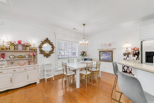 43 Earnhardt Cir, Cabot, AR 72023 - dining area featuring light wood-style floors, a chandelier, baseboards, and crown molding