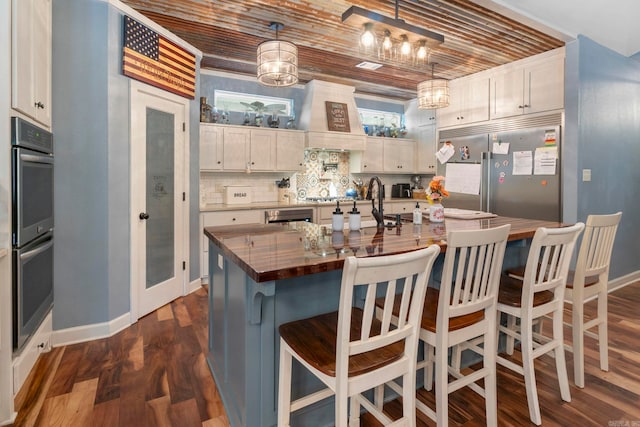 10820 W Sardis Rd, Bauxite, AR 72011 - kitchen with stainless steel appliances, decorative backsplash, baseboards, dark wood-type flooring, and custom exhaust hood