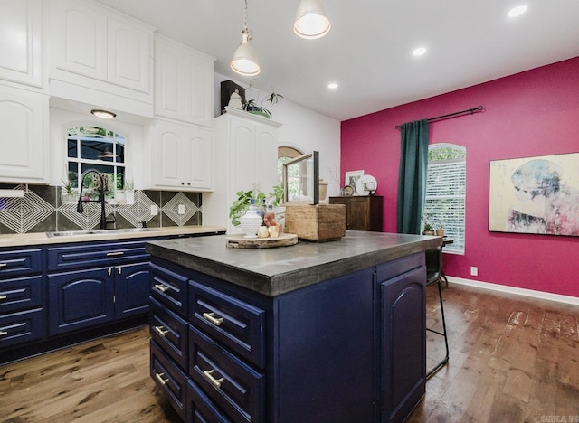 1112 Lawrence Ln, Benton, AR 72019 - kitchen featuring blue cabinets, a sink, wood finished floors, white cabinets, and a kitchen island