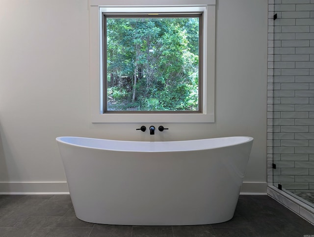80 Stone Cir, Greers Ferry, AR 72067 - full bathroom with baseboards, a freestanding tub, tile patterned flooring, and a tile shower