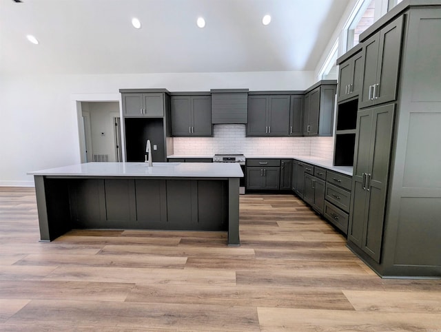 80 Stone Cir, Greers Ferry, AR 72067 - kitchen with stainless steel range with electric cooktop, a center island with sink, decorative backsplash, light countertops, and recessed lighting