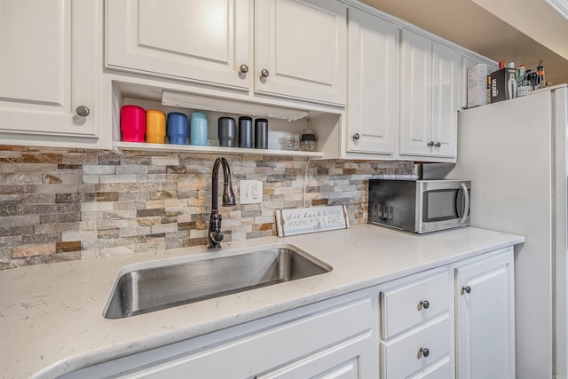100 Discovery Bay Ln Unit 6, Hot Springs, AR 71913 - kitchen with open shelves, stainless steel microwave, a sink, white cabinetry, and tasteful backsplash