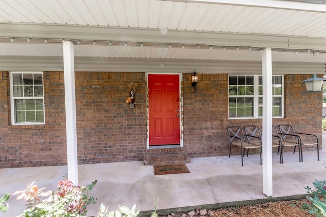 64 Castleberry Rd, Greenbrier, AR 72058 - doorway to property featuring a porch and brick siding