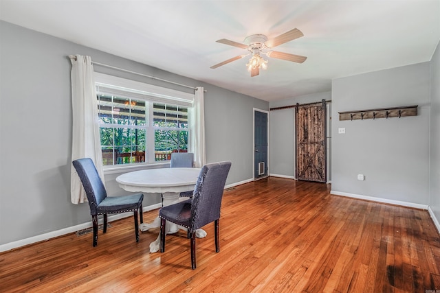 64 Castleberry Rd, Greenbrier, AR 72058 - dining area with light wood finished floors, a barn door, ceiling fan, and baseboards