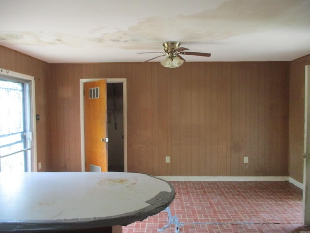 1407 E 38th St, Little Rock, AR 72206 - dining room with brick patterned floors, wooden walls, a ceiling fan, and baseboards