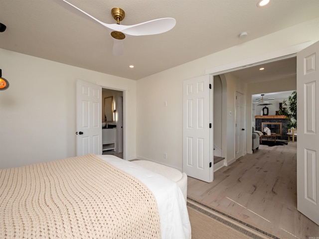 15 Brandywine Ln, Little Rock, AR 72227 - bedroom featuring light wood finished floors, recessed lighting, a stone fireplace, ceiling fan, and baseboards