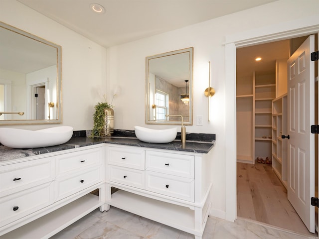 15 Brandywine Ln, Little Rock, AR 72227 - full bathroom with double vanity, a walk in closet, marble look tiles, and recessed lighting