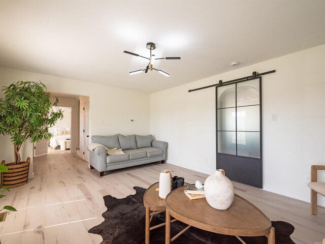 15 Brandywine Ln, Little Rock, AR 72227 - living area with a barn door, light wood finished floors, baseboards, and a chandelier