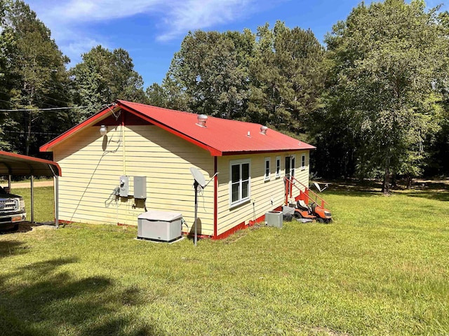 view of home's exterior with a lawn, a carport, and metal roof
