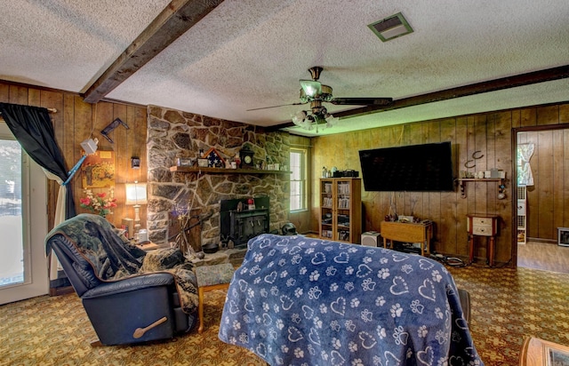 826 Carson Bridge Rd, Lonoke, AR 72086 - living room with wooden walls, a textured ceiling, beam ceiling, a ceiling fan, and a fireplace
