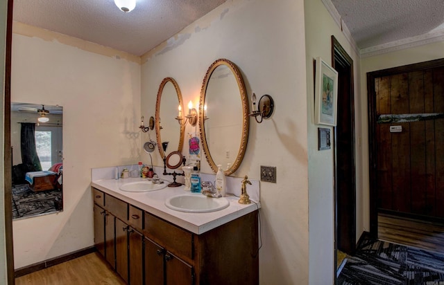 826 Carson Bridge Rd, Lonoke, AR 72086 - full bath featuring a textured ceiling, wood finished floors, double vanity, and baseboards