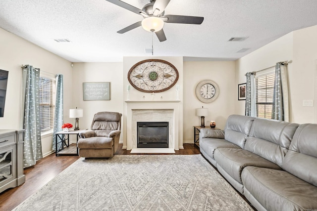 2806 Sundance Cir, Benton, AR 72015 - living room with dark wood-style flooring, ceiling fan, a fireplace, a textured ceiling, and baseboards