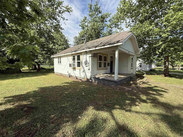 414 E 1st St, Rector, AR 72461 - rear view of house with a lawn, a shingled roof, cooling unit, and covered porch