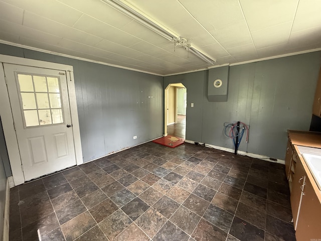 414 E 1st St, Rector, AR 72461 - unfurnished dining area with ornamental molding, arched walkways, wooden walls, and baseboards