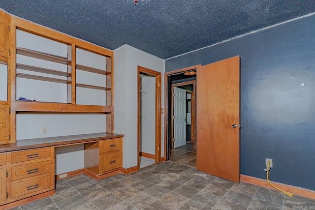 812 Glendale St, Jonesboro, AR 72401 - unfurnished office featuring built in desk, baseboards, and stone finish flooring