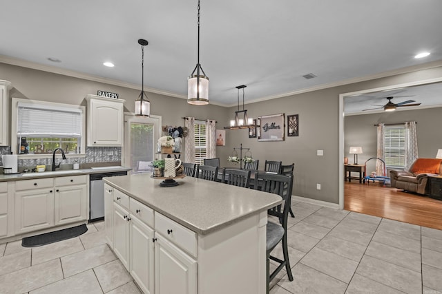 108 Chimney Rock Rd, Beebe, AR 72012 - kitchen featuring a sink, stainless steel dishwasher, light tile patterned flooring, a kitchen bar, and crown molding