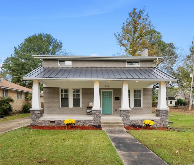 219 W D Ave, North Little Rock, AR 72116 - view of front facade with covered porch, brick siding, and metal roof