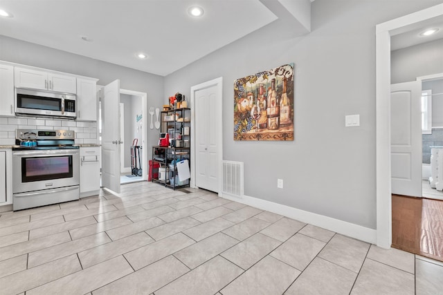 219 W D Ave, North Little Rock, AR 72116 - kitchen featuring appliances with stainless steel finishes, recessed lighting, white cabinetry, decorative backsplash, and light countertops