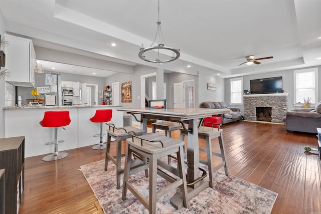 219 W D Ave, North Little Rock, AR 72116 - dining area featuring a raised ceiling, ceiling fan, hardwood / wood-style floors, recessed lighting, and a fireplace