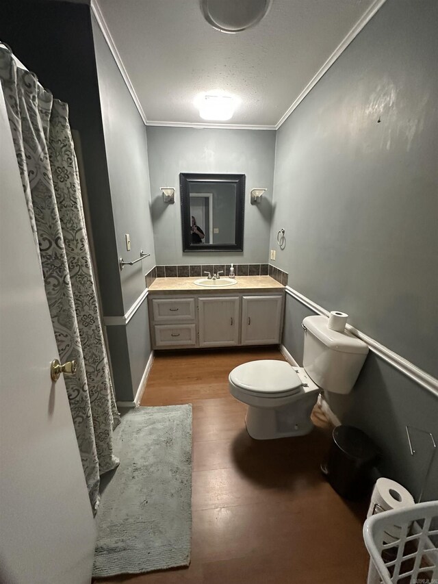 213 S Adcock, Dumas, AR 71639 - bathroom with toilet, ornamental molding, vanity, wood finished floors, and a textured ceiling