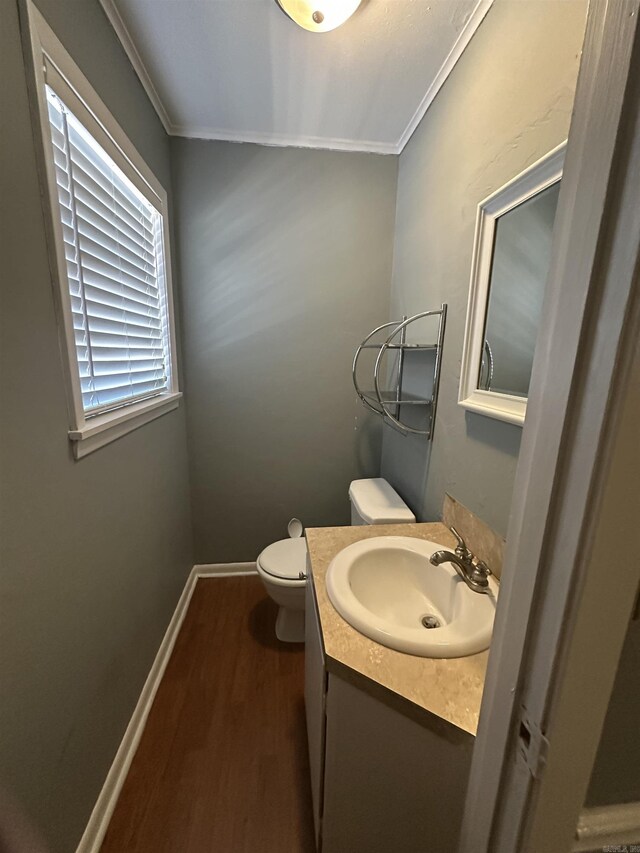213 S Adcock, Dumas, AR 71639 - bathroom featuring wood finished floors, crown molding, toilet, vanity, and baseboards
