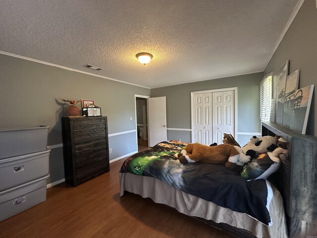 213 S Adcock, Dumas, AR 71639 - bedroom featuring a textured ceiling, wood finished floors, a closet, ornamental molding, and baseboards