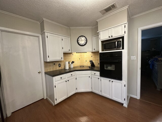 213 S Adcock, Dumas, AR 71639 - kitchen with oven, dark wood-style flooring, stainless steel microwave, white cabinetry, and a textured ceiling
